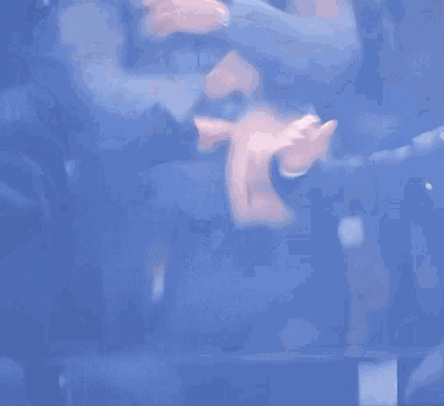 a blurry picture of a person sitting in a chair with their hands in the air