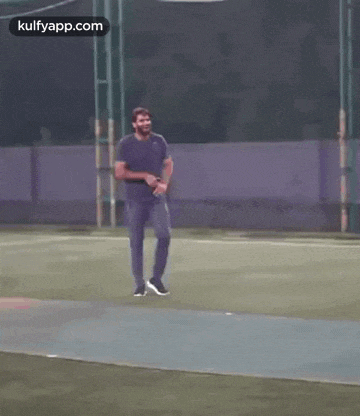 a man is walking on a soccer field .