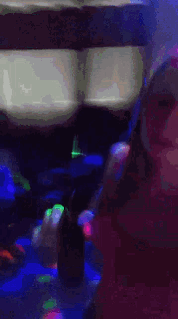 a woman is dancing in a dark room with a lot of lights behind her