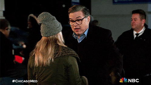 a man and a woman are standing next to each other with a nbc logo in the corner