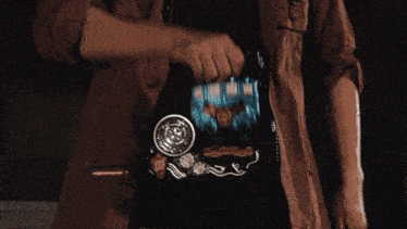 a man standing in a dark room with a glowing object on his chest