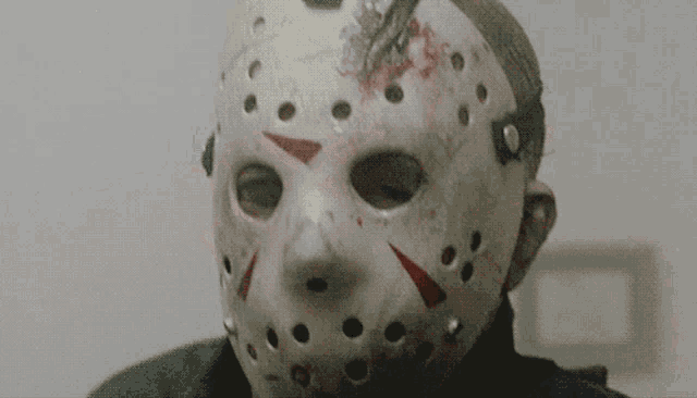 a person wearing a jason voorhees mask with blood coming out of it