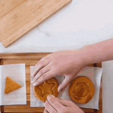 a person is making a star shaped cookie on a cutting board .