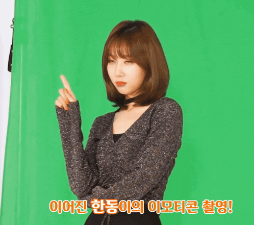 a woman in front of a green screen with korean writing