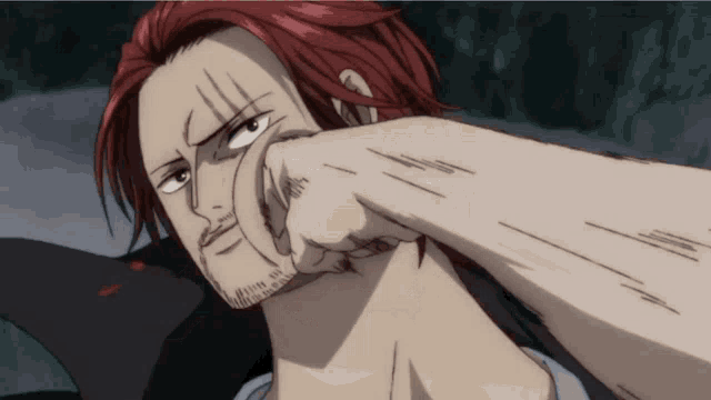 a man with red hair and a beard has his fist in his face