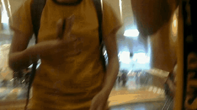 a man in a yellow shirt is holding someone 's hand