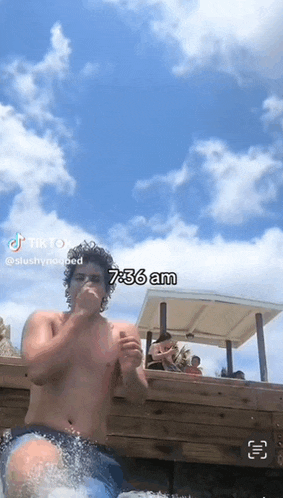 a shirtless man is standing in a pool with the time of 6:36 am