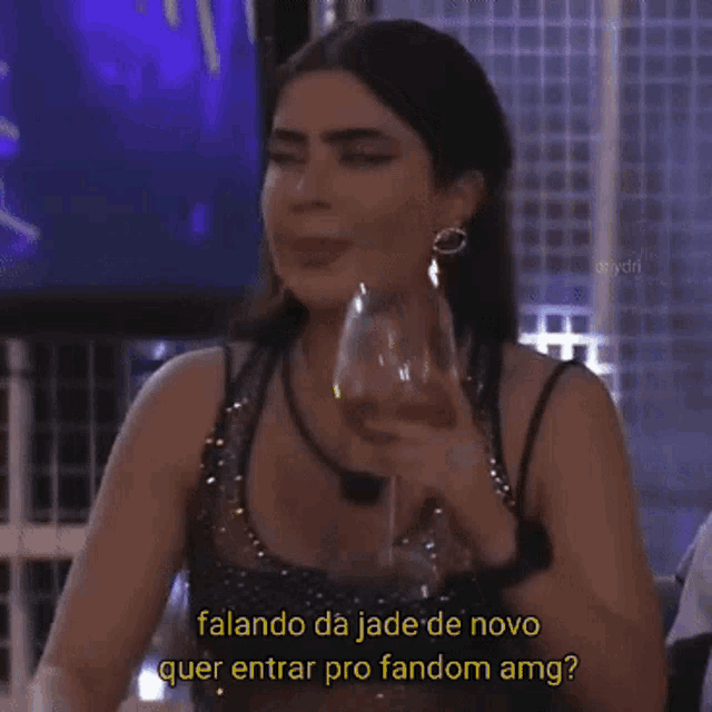a woman drinking a glass of wine with a caption that says " falando da jade de novo "