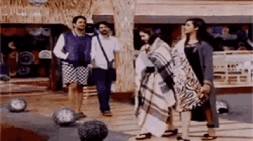 a group of people are standing in front of a building and talking to each other .