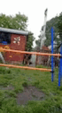 a blurry picture of a wrestling ring in a park with a brick building in the background .