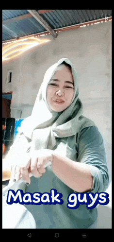 a woman wearing a hijab is holding a knife and the words " masak guys " are on the bottom