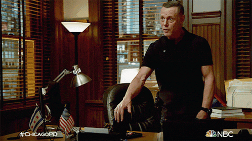 a man in a black shirt is standing in front of a desk with the hashtag #chicagopd on it