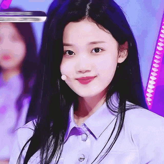 a girl with long black hair is wearing a purple shirt that says hey
