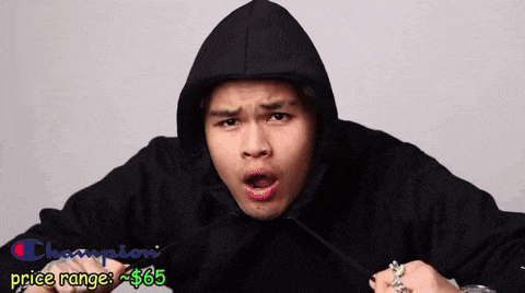 a man wearing a black champion hoodie with the price range of $ 65