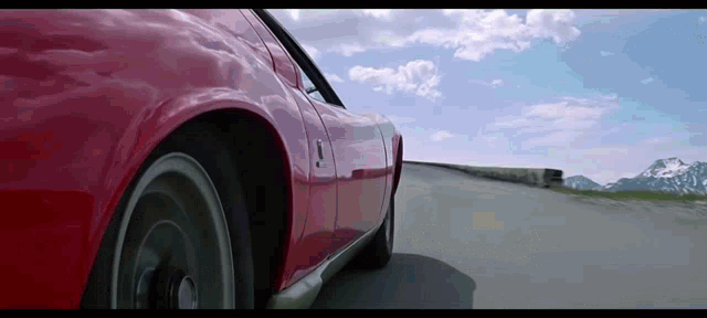 a red car is driving down a road with the number 9 on the side
