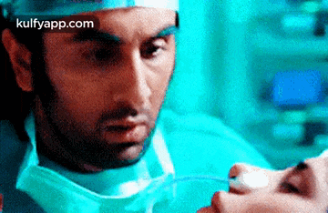 a close up of a man in a surgical mask holding a woman 's hand .