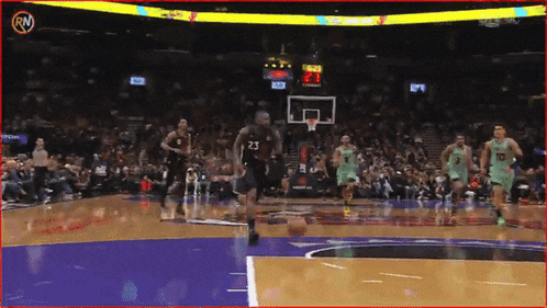 a basketball player with the number 23 on his shorts is dribbling the ball