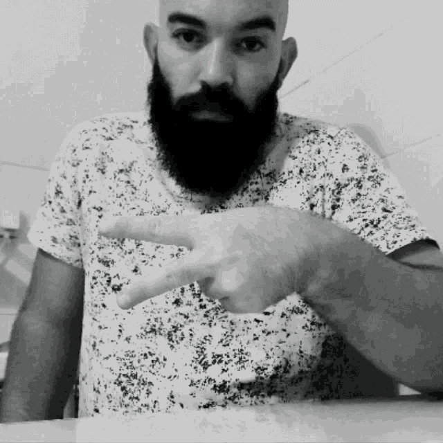 a man with a beard is pointing at something with his finger