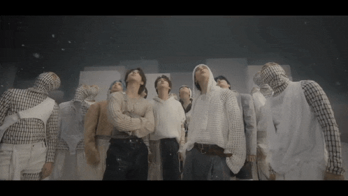 a group of people standing in a dark room looking up at the sky