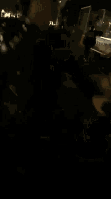 a group of people are standing in a dark room at night .