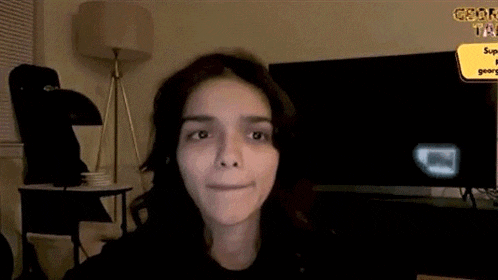 a woman with a black eye is sitting in front of a tv and a sign that says george on it