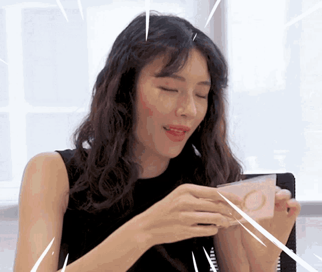 a woman in a black top is holding a card with a circle on it