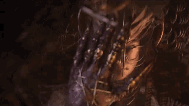 a close up of a person 's face in a dark room with a sword in their hand .