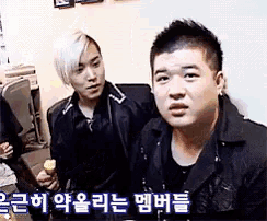 two men are sitting next to each other and one of them is holding an ice cream cone ..