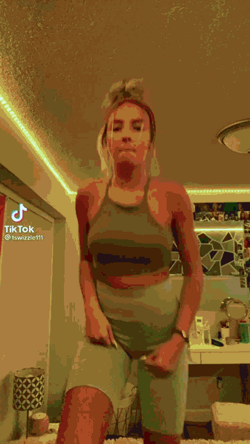 a woman is dancing in a room with tiktok written on the bottom right