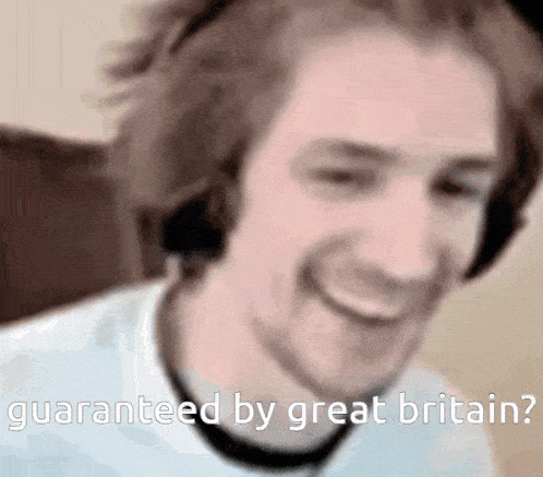 a man wearing headphones is smiling and says `` guaranteed by great britain ''