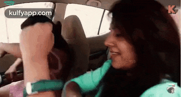 a woman is sitting in the driver 's seat of a car holding a man 's hand .