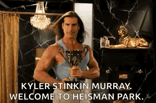 kyler stinkin murray is holding a trophy in a bathroom and saying welcome to heisman park .