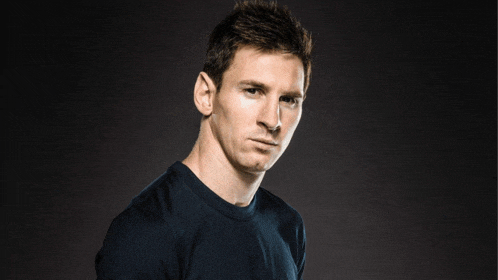 a man in a black shirt looks at the camera with a serious look on his face