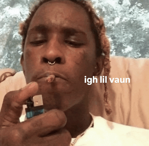 a man lighting a cigarette with the words igh lil vaun written on the bottom