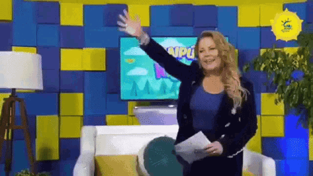 a woman is standing in front of a tv screen that says " campus "