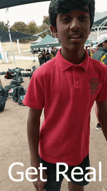 a young boy wearing a red shirt with the words get real written on the bottom