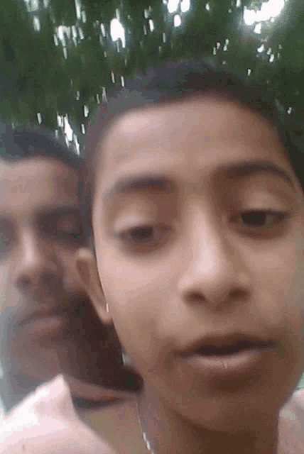 a close up of a person 's face with a man behind them