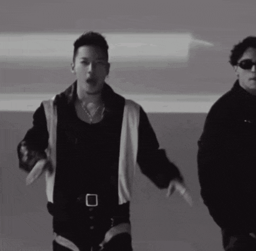 two men are dancing in a black and white photo with one wearing sunglasses