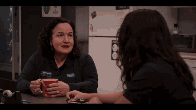 two women are sitting at a table with the words of course written on the screen