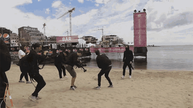 a group of people standing on a beach in front of a bar