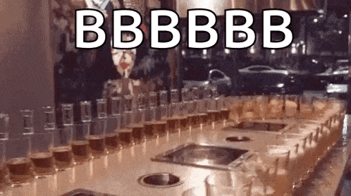 a row of shot glasses sitting on top of a table with the words `` bb bb bb '' written on it .