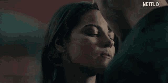 a close up of a woman kissing a man with a netflix logo in the background