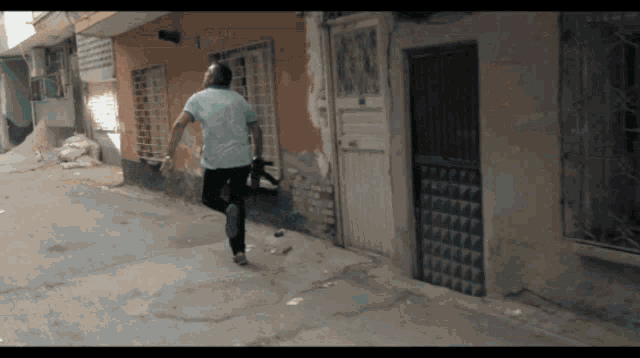 a man in a blue shirt is running down a sidewalk