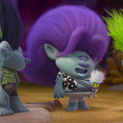 a troll with purple hair is holding a feather in his hand
