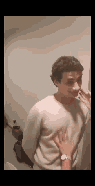 a man in a white sweater is being touched by a woman .