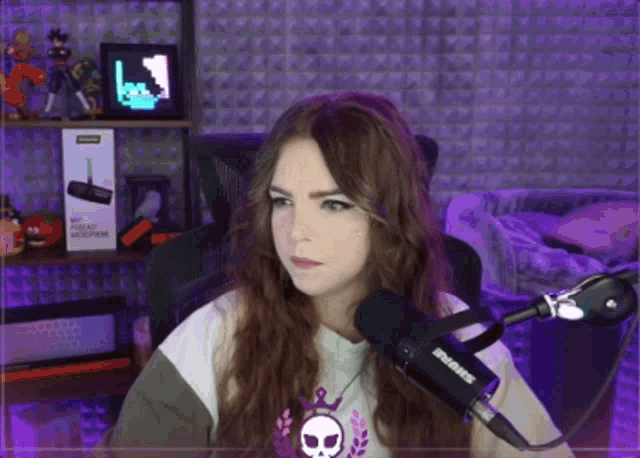 a woman sitting in front of a shure microphone in a room