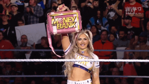 a woman in a wrestling ring holding a money in the bank briefcase