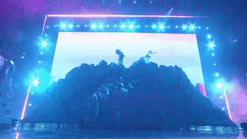a group of people standing on top of a mountain in front of a screen