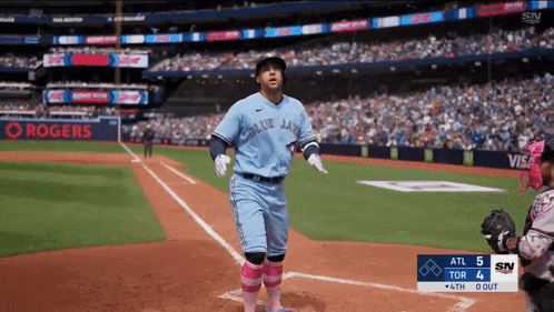 a baseball player wearing a blue jays uniform stands on a field