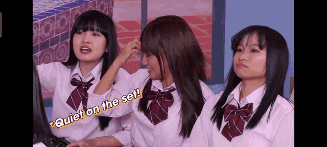 three girls in school uniforms are sitting next to each other with quiet on the set written on the bottom